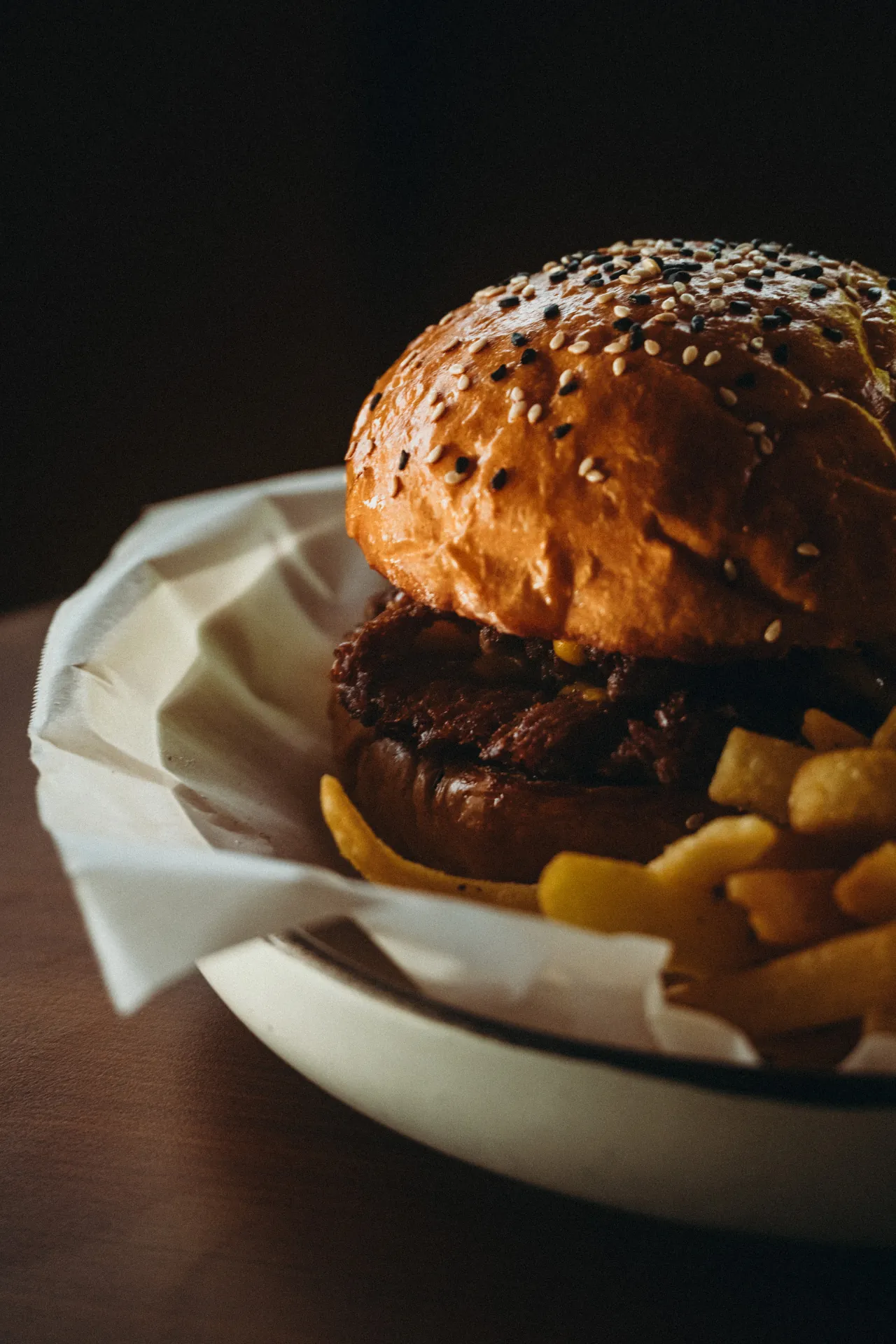 Close-up of a sesame brioche cheeseburger with fries at The Lakehouse