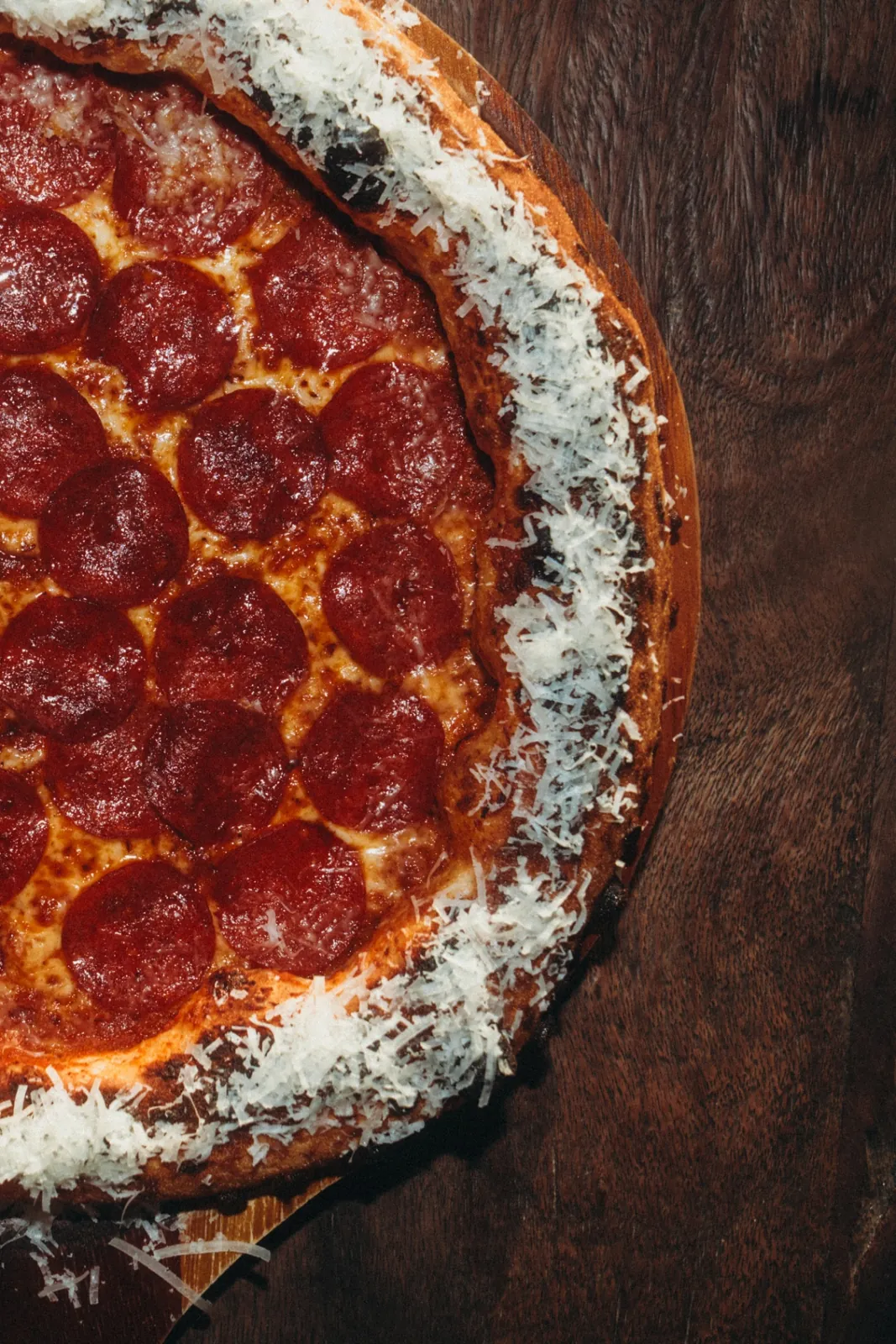 Wood-fired pepperoni pizza with a golden charred crust and grated parmesan at The Lakehouse